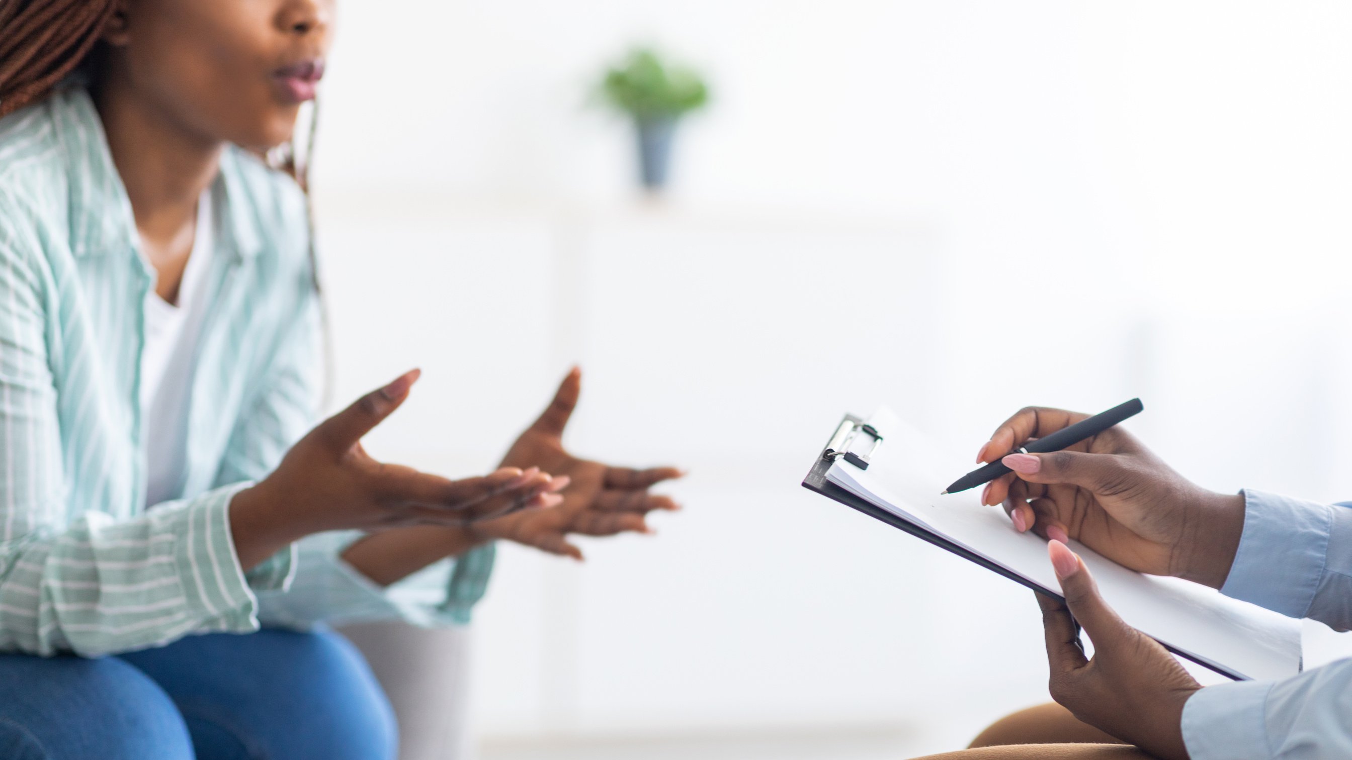 Psychologist providing professional psychological help to black female patient at clinic, closeup